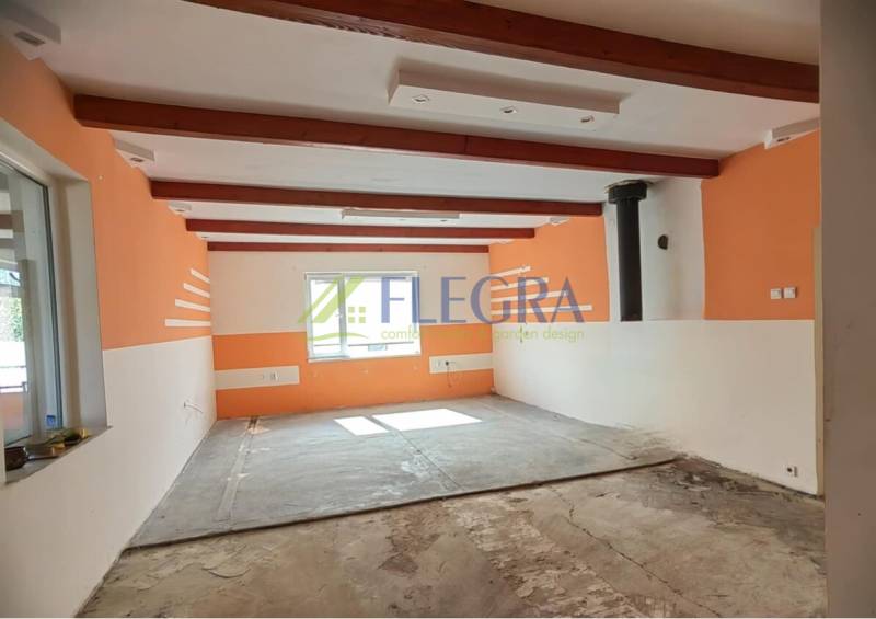 Interior of a family house with exposed wooden beams and light orange walls.