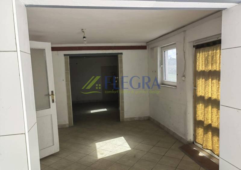 The interior of a family house with tiles and windows that let in light.