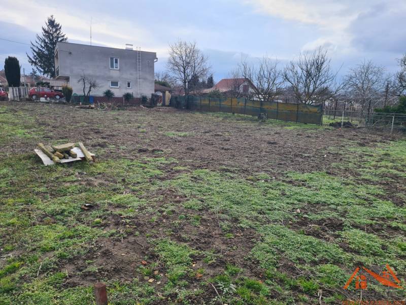 A plot for residential use in Svätý Peter with an older house and a landscaped garden.