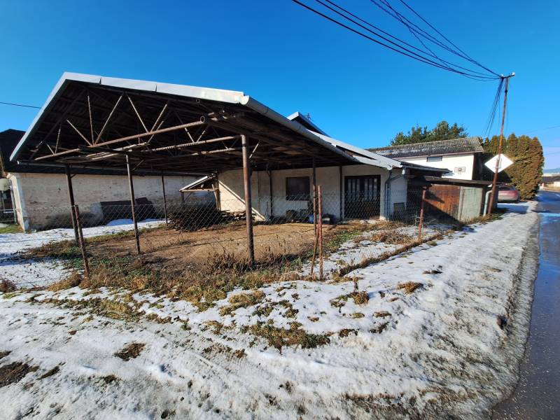 A warehouse structure and a snowy road in Medzany.