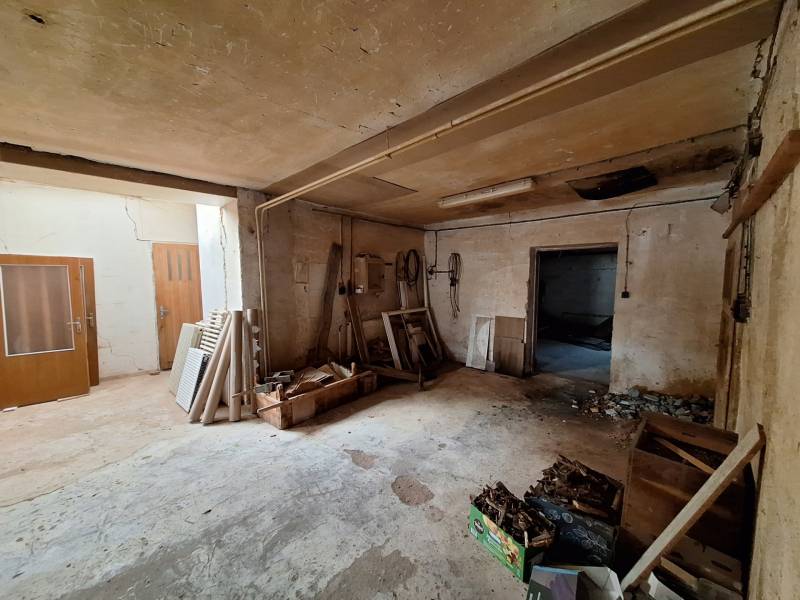 Interiors of warehouses and halls with stored wood and various building materials.