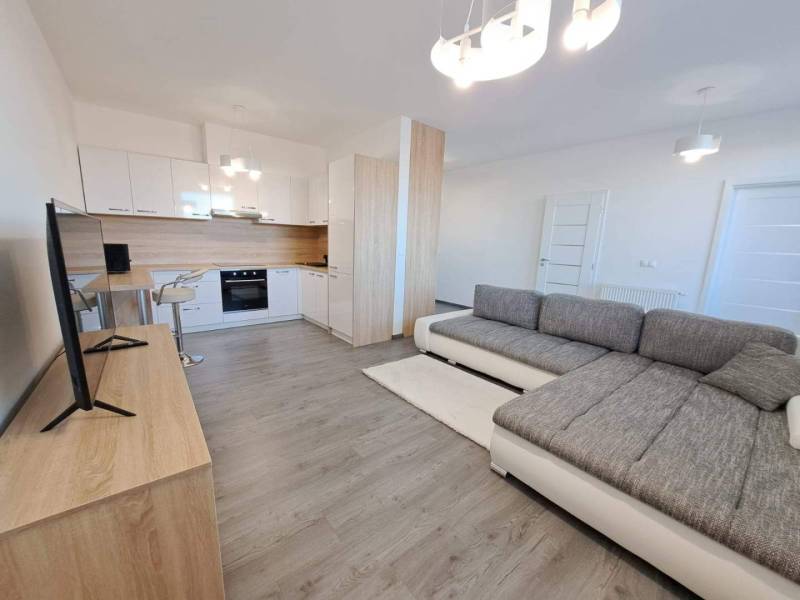 Living room with kitchen in a 2-room apartment and a floor with a wooden decor.
