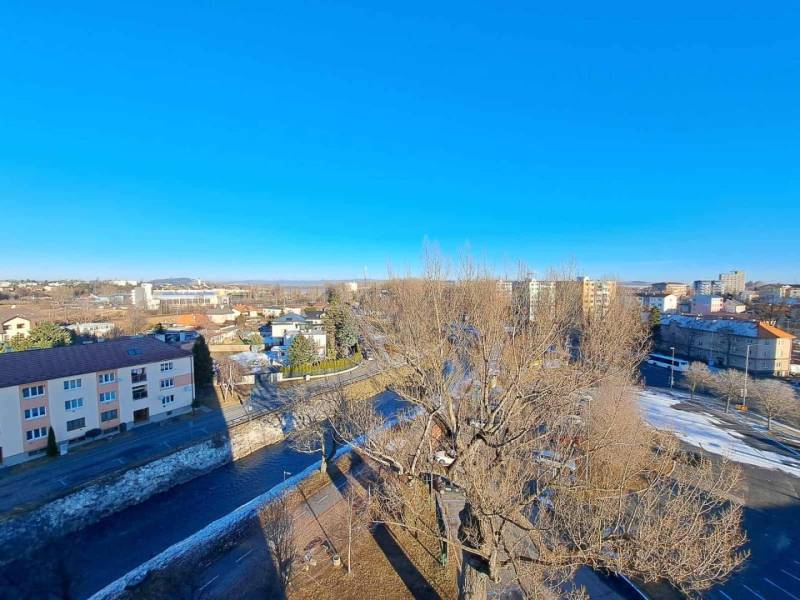 A view of a district in Poprad with residential buildings and a road in the winter season.
