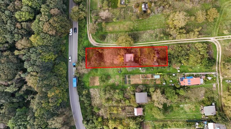 Aerial view of a garden cottage in Hlohovec surrounded by greenery and a road.