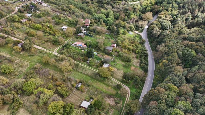 Garden area with cottages around Hlohovec surrounded by greenery and a road.