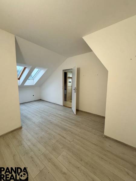 A studio apartment with a wooden decor floor and skylights.