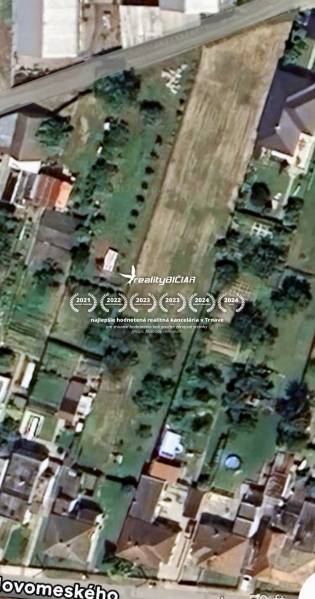 Aerial view of residential plots in Hlohovec with gardens and houses.