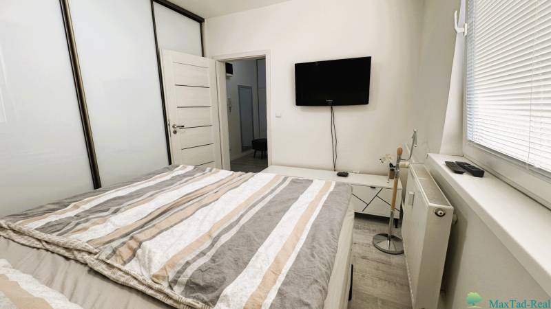 Bedroom in a 3-room apartment with a TV, wardrobe, and bed.