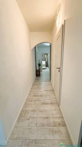 A hallway with pale tiles and white walls in a 3-room apartment.