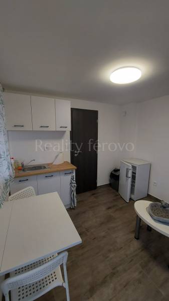 A kitchen in a cottage with a table, chairs, and a floor with a wooden decor.