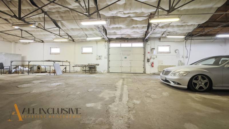 Space with a garage door and stored materials, commercial premises.