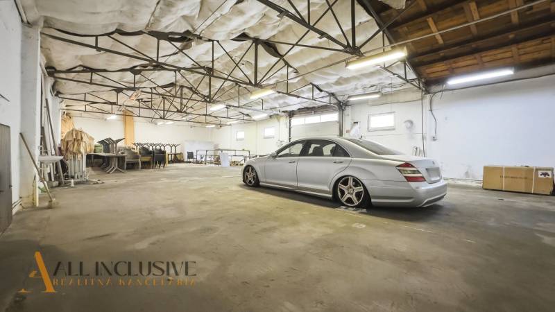 A car parked in commercial premises with an industrial ceiling and storage space.