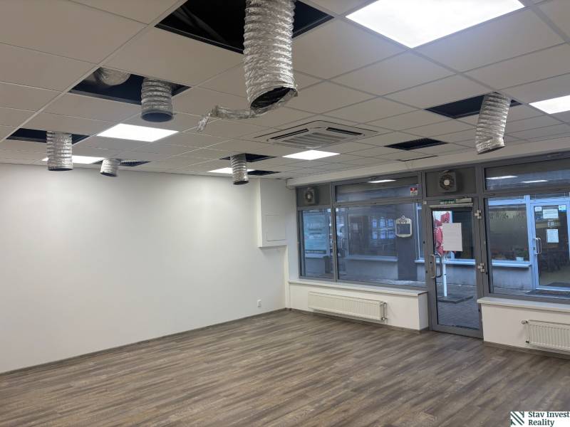 Commercial premises with wood-patterned flooring and ceiling ventilation.