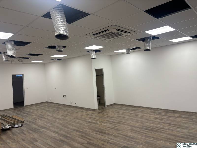 Commercial spaces with ceiling vents and wood-patterned flooring, unfurnished.