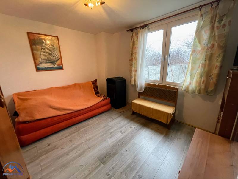 Living room in a cabin with a comfortable sofa and a wooden decor floor.