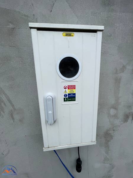 White electrical box with a label at the cottage in Komárno.