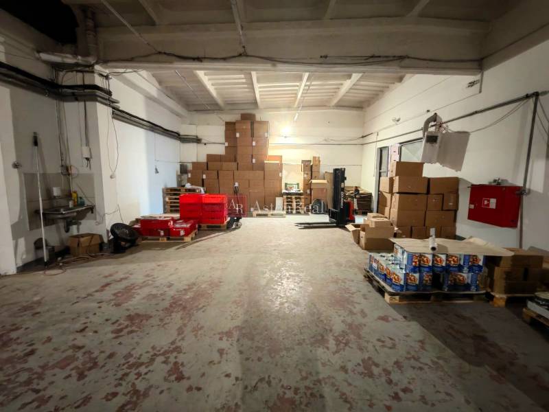 Warehouses and halls with stored boxes and pallets, high ceilings, industrial style.