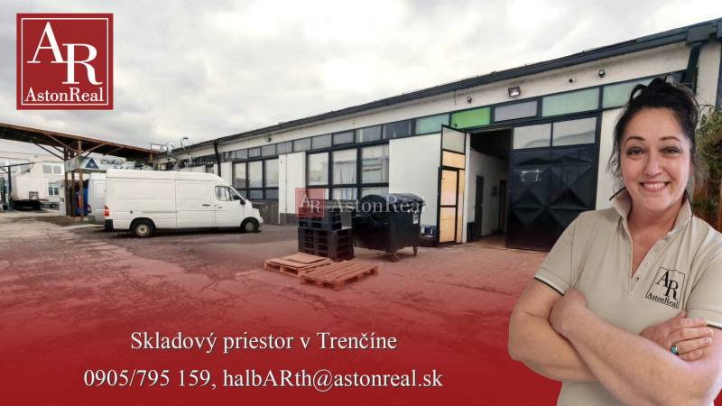 A building of warehouses and halls with cars in Trenčín, highlighted company advertisement in the foreground.