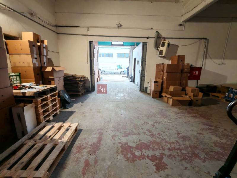 Warehouses and halls with a multitude of cardboard boxes and pallets on a worn-out floor.