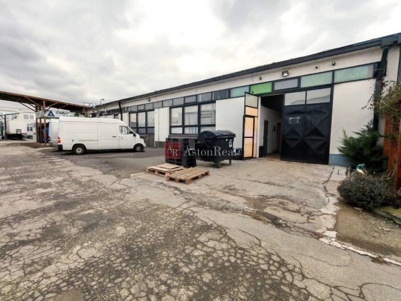 In the yard in Trenčín, there are industrial warehouses and halls with a vehicle.