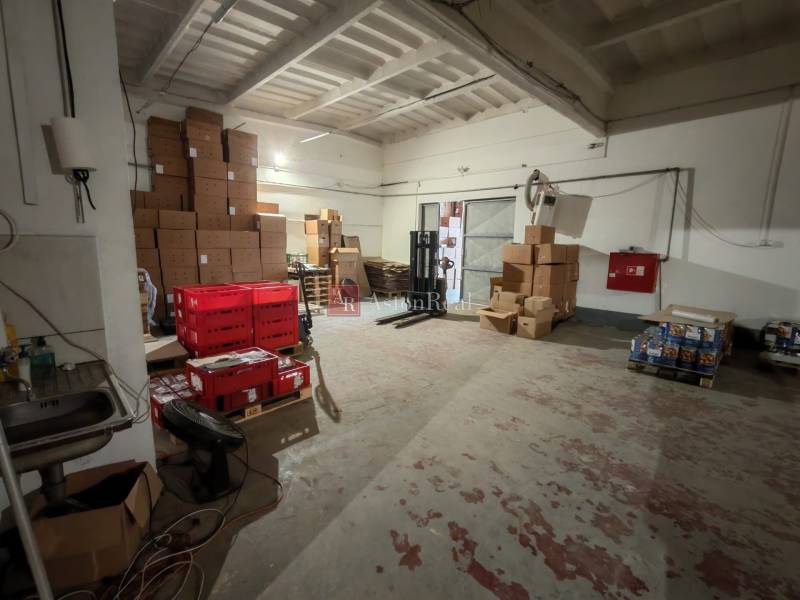 Warehouses and halls with stacks of cardboard boxes and red crates.