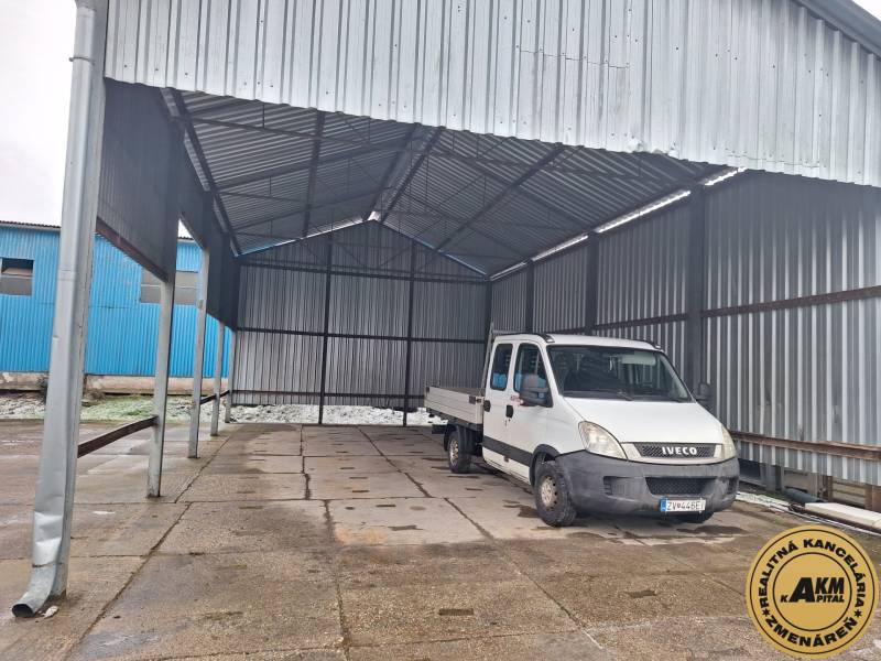 The car is parked under a metal shelter in the area of Warehouses and Halls on Lieskovská Road in Zvolen.