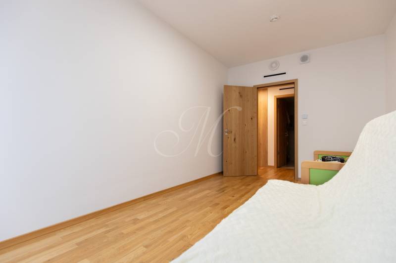 A room in a 3-room apartment with white walls and a floor with a wooden decor.