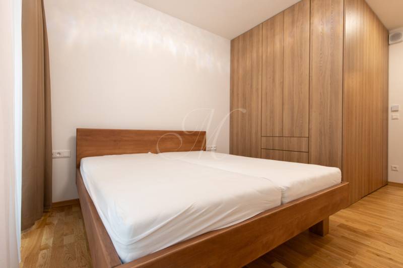 Bedroom in a 3-room apartment with a bed and a wardrobe, floor with wooden decor.