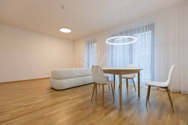 Living room with wood-decor flooring, sofa, table, and chairs in a 3-room apartment.