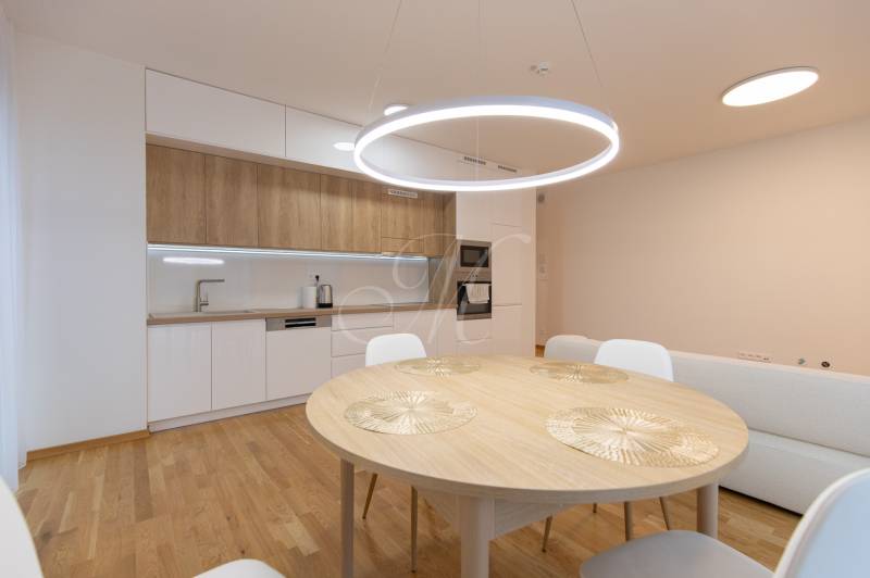 A kitchen in a 3-room apartment with a table and a wooden decor floor.