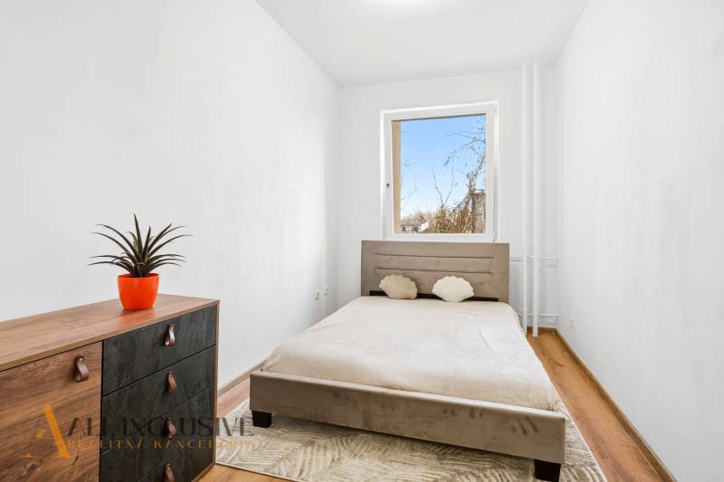 Bedroom in a 3-room apartment with a light bed and a cabinet with a wood-patterned floor.