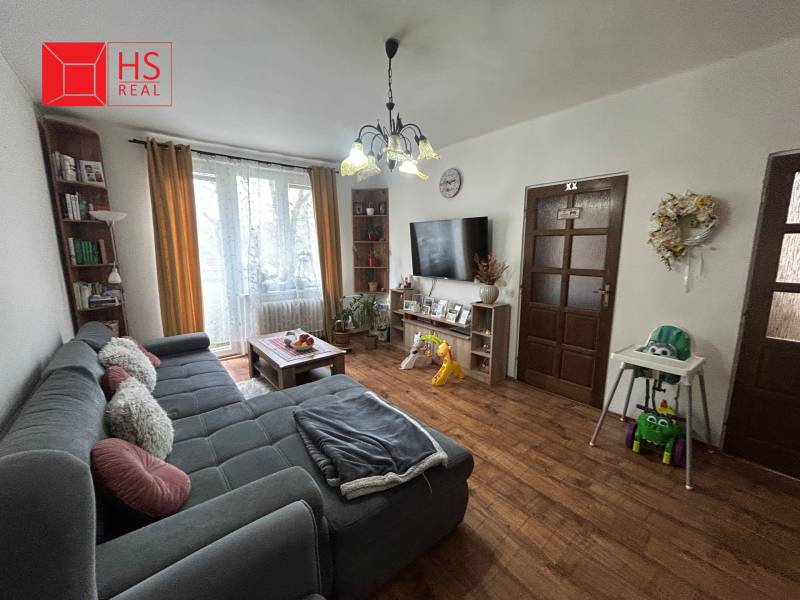 Living room in a 3-room apartment with a comfortable sofa and a floor with a wooden decor.