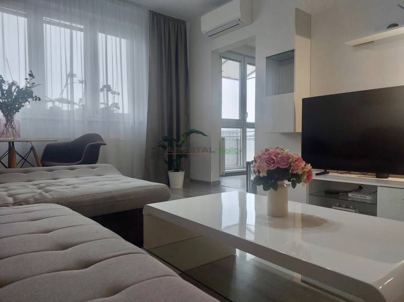 Living room with a comfortable sofa and a large window, 2-room apartment.