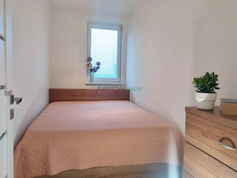 Bedroom with a comfortable bed and decorations in a 2-room apartment.