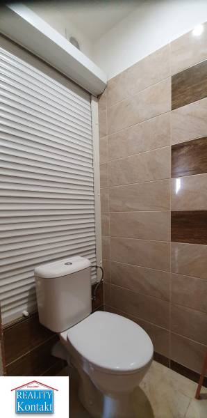 Bathroom with toilet and beige tiles in a 2-room apartment.