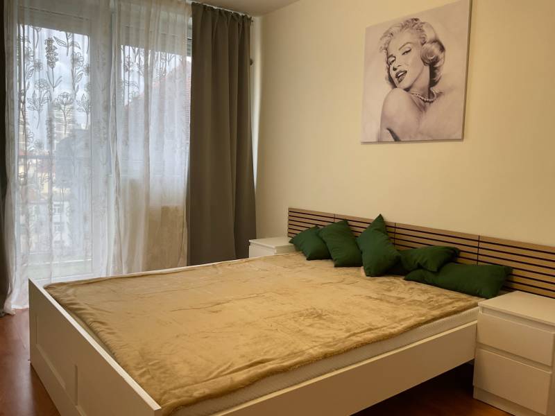 Bedroom in a 3-room apartment, bed with wooden decor and artwork on the wall.