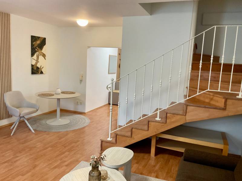 Interior of a 3-room apartment with a wooden decor floor and a staircase.