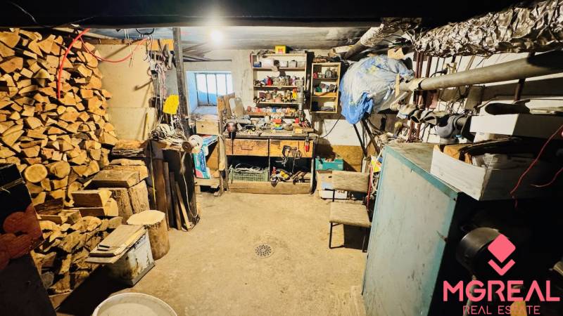Workshop in a family house with tools, wood, and a workbench.
