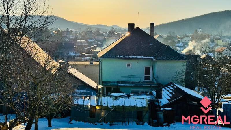 A snowy landscape with a family house in Horné Vesie, surrounded by snow-covered roofs and trees.