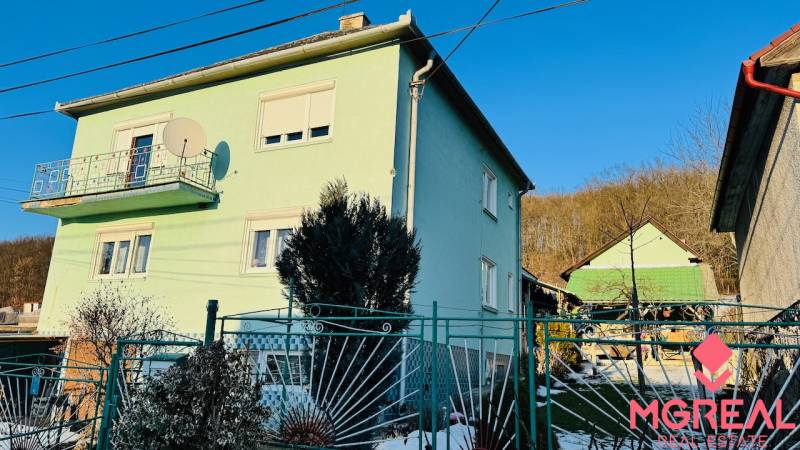 A family house in Horná Ves with a colorful facade and a garden, sunny day.