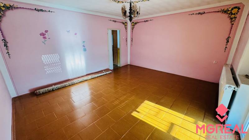 A room in a family house with brown tiles and pink floral decorations on the walls.