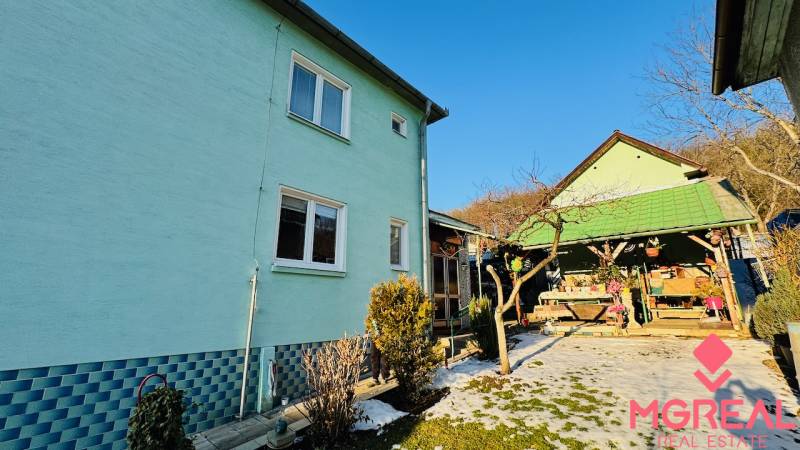 A family house in Horná Ves with a yard and a gazebo, surrounded by greenery and a blue facade.