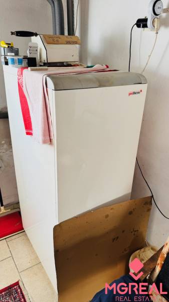 A boiler in a family house with a sand container and tools.