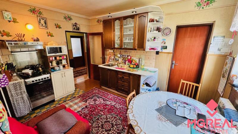 A kitchen in a family house with carpet and wooden cabinets, feels cozy.