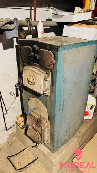 A fireplace in the basement of a family house in Horná Ves, on a stand with storage space.