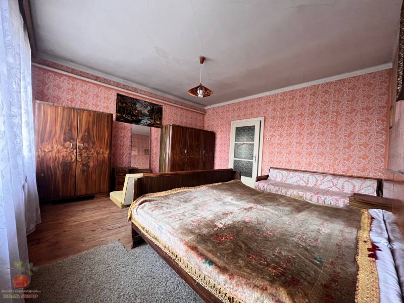 A bedroom in a family house with a wooden decor floor and upholstered furniture.
