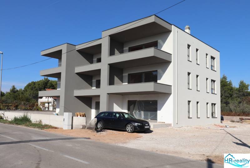 A recreational apartment in Vodice with balconies and a car on the driveway.