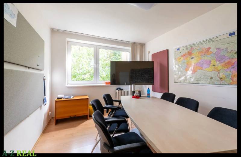 Meeting room in a family house with a map on the wall and a screen, floor with wooden decor.