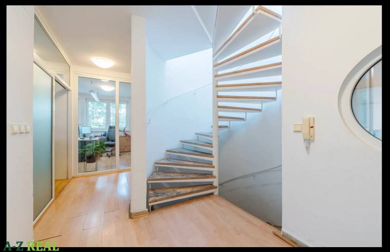 Interior of a family house, spiral staircase, wooden decor flooring, glass doors.