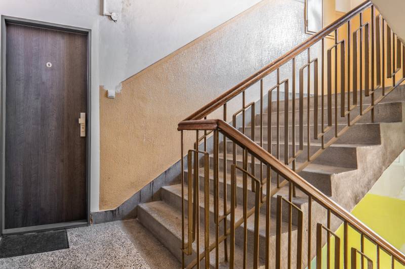 A staircase with a wooden railing and entrance doors in Bratislava - Staré Mesto, Heydukova.